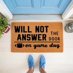Football game day doormat with funny text that says will not answer the door on game day, featuring a football graphic on a natural coir fiber welcome mat for a front porch entrance, perfect for sports fans and home decor