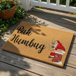 Bah Humbug Christmas doormat featuring a funny illustration of a man in a red suit sitting on a chimney while smoking, this natural coir welcome mat is a humorous holiday floor rug for your front porch or entryway decor.
