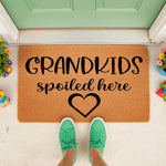 Grandkids Spoiled Here coir doormat for grandparents, featuring a natural fiber welcome mat with black text and a heart design, perfect for a front porch entry way to celebrate family and home decor with a fun, personalized look.
