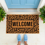 Leopard print welcome doormat featuring a bold animal pattern and black text on a natural coir fiber mat, placed at a blue front door entrance to create a stylish porch decor look for your home entryway and outdoor floor space.