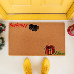 Naughty or Nice Christmas doormat featuring a pile of coal and a wrapped gift box design on natural coir fiber, perfect for holiday porch decor and festive entryway welcome mats for the winter season at your front door.