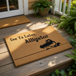 Alligator welcome doormat featuring a funny cartoon reptile illustration and the text See Ya Later Alligator, this natural coir fiber outdoor entry rug is a humorous front porch decor piece for any home entrance or housewarming.