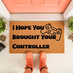 Gaming doormat with I Hope You Brought Your Controller text and a controller icon, this funny gamer welcome mat is a natural fiber floor rug for a front porch entrance, perfect for video game lovers and home decor enthusiasts.