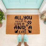 Cat lover welcome doormat featuring a funny quote about needing love and a cat, printed on a natural coir fiber mat for a front porch entrance, with cute paw prints and feline silhouettes for a pet owner home decor entryway