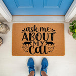 Ask Me About My Cat doormat featuring black text and feline silhouettes on a natural coir fiber welcome mat, placed on a front porch for cat lovers who want a funny, decorative, and durable outdoor floor rug for their home