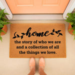 Home quote doormat featuring natural coir fiber material with black script text, perfect as a personalized front porch welcome mat for housewarming decor, placed on a concrete entryway floor with potted ferns and a peach colored