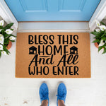 Bless This Home doormat featuring a natural coir fiber welcome mat with black text and house icons, placed on a porch in front of a blue door, making a functional housewarming decor piece for your entryway or front door step.