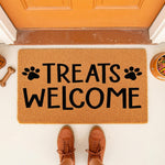Treats Welcome dog doormat for pet lovers, featuring a natural coir fiber welcome mat with black paw prints and text, placed on a porch with a bowl of dog food and a bone toy for a fun, pet-friendly home entrance decor look.