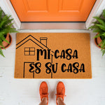 Mi Casa Es Su Casa doormat featuring a house outline on natural coir fiber, this funny welcome mat for front porch entryways adds a warm touch to home decor with its inviting Spanish phrase printed in bold black lettering.