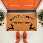 Personalized Happy Holidays doormat with reindeer design, featuring a custom family name on a natural coir welcome mat for front porch decor, perfect for winter seasonal home entryways and festive outdoor holiday floor mats.