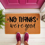 No Thanks We Are Good doormat featuring funny text on a natural coir welcome mat, placed on a white porch in front of a bright pink door, making a humorous front door rug for home entryways and housewarming decor for any modern