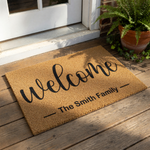 Personalized family name welcome doormat featuring a natural coir fiber texture with elegant black script text, this custom outdoor entrance mat is a durable housewarming decor piece for your front porch or entryway floor.