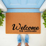 Personalized family name welcome doormat featuring natural coir fiber material, displayed on a front porch with a blue door, perfect for a custom housewarming entrance rug or a durable outdoor welcome mat for your home entryway.