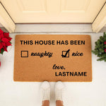 Personalized Christmas doormat featuring a naughty or nice checklist design on natural coir fiber, perfect for holiday front porch decor, with custom family name text for a festive seasonal welcome mat at your front door entrance.