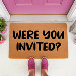 Funny Were You Invited doormat for front porch, featuring bold black text on a natural coir fiber welcome mat, perfect for a humorous home entrance decor style that greets guests with a witty message at your front door entryway.