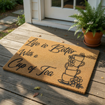 Life is Better With a Cup of Tea coir doormat featuring a stack of teacups and floral designs, this natural fiber welcome mat is a stylish front porch decor piece for tea lovers and home entryways looking for a cozy kitchen vibe.