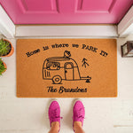 Personalized camping doormat featuring a travel trailer illustration and the text Home is where we park it, this custom coir welcome mat is a fun outdoor floor rug for campers, RV owners, and travel enthusiasts at their front