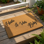 Funny Hasta La Vista Baby doormat featuring bold black script text on a natural coir fiber mat, this durable outdoor welcome mat is a humorous front porch decor piece for movie fans looking for a unique entryway floor rug for
