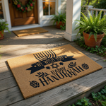 Hanukkah welcome doormat featuring a black menorah, star of David, and dreidel design on a natural coir fiber mat, perfect for holiday home decor and festive entryway floor mats during the winter season for a warm seasonal