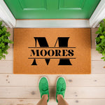 Personalized family name doormat featuring a large black letter M monogram on a natural coir fiber welcome mat, perfect for front porch decor and housewarming entryways to create a stylish and inviting home entrance for guests.