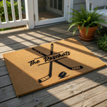 Personalized hockey doormat featuring crossed sticks and a puck design on natural coir fiber, this custom family name welcome mat is a durable outdoor floor rug for sports fans and hockey players looking for home entrance decor.