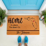 Personalized Florida state map doormat with a red heart, featuring the text Home Is Where The Heart Is on a natural coir welcome mat, perfect for a custom family name front porch entrance decor or a housewarming entry rug.