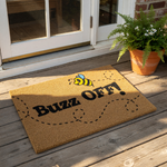 Funny bee doormat with a natural coir texture, featuring a cute cartoon bee illustration and the text Buzz Off printed in bold black letters, making this a humorous welcome mat for your front porch or entryway home decor.