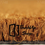 A close-up view of a textured surface, possibly a woven material or a natural plant fiber, with a warm, golden-brown color.