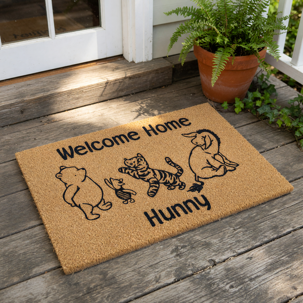 Welcome Home Hunny coir doormat featuring a cute bear, a small piglet, a striped tiger, and a donkey character illustration, making this natural fiber welcome mat a fun front porch decor piece for any cartoon lover's house