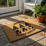 Happy Thanksgiving coir doormat featuring three cute gnomes with fall hats, a pumpkin, and autumn leaves.