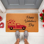 Happy Valentine's Day doormat featuring a red truck carrying hearts on a natural coir welcome mat, perfect for seasonal porch decor, entryway floor mats, and romantic holiday home entrance styling for a festive front door look.