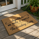 Personalized family name doormat featuring the phrase together we make a family in black script and block lettering on a natural coir fiber welcome mat, perfect for a custom housewarming gift or front porch decor for any home.