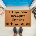 Funny I Hope You Brought Snacks doormat featuring food icons on a natural coir welcome mat, perfect for a movie night porch decor theme with a popcorn bucket and film reel accents on a white front porch floor by a bright blue