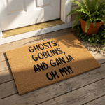 Funny Halloween doormat featuring the text Ghosts, Goblins, and Ganja Oh My printed in black on a natural coir fiber welcome mat, perfect for a spooky front porch entry or a humorous home decor statement for cannabis enthusiasts.