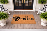 Personalized artist family doormat featuring a paint palette and brush design on natural coir fiber, perfect for a front porch entryway.