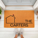 Personalized family name doormat featuring a house outline with a red heart on a natural coir welcome mat, perfect for a front porch entry.