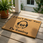 Gaming doormat with I Can't Hear You I'm Gaming text and a headset controller graphic, this funny gamer welcome mat is made of natural coir fiber and is a perfect front door rug for any video game room or home office entrance.