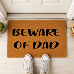 a door mat that says beware of dad