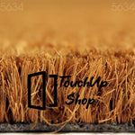A close-up view of a textured surface, possibly a woven material or a natural plant fiber, with a warm, golden-brown color.