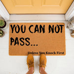 Funny welcome doormat with the text You Can Not Pass Unless You Knock First, featuring a natural coir fiber texture on a front porch, making a humorous entryway rug for fantasy fans and home decor enthusiasts looking for a unique
