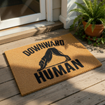 Funny yoga dog doormat featuring a black silhouette of a dog in a downward dog pose with the text Downward Human, this natural coir fiber welcome mat is a humorous home decor piece for yoga lovers and pet owners alike.