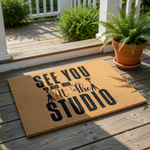 Photography studio doormat with See You At The Studio text and camera icons on a natural coir welcome mat, perfect for a photographer front porch decor or a creative business entrance floor mat for a home studio or office space.