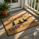 Cats own this house doormat featuring three black cat silhouettes on a natural coir fiber welcome mat, a funny pet lover floor rug for front porch entryways that makes a great housewarming decor piece for any cat owner home.