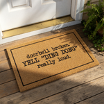 Funny doorbell broken doormat with a natural coir texture and black border, featuring the text YELL DING DONG really loud for a humorous front porch welcome mat that serves as a quirky housewarming decor piece for your home