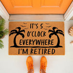 Retirement tropical doormat featuring palm trees and the text It's 5 O'Clock Everywhere I'm Retired, this funny outdoor welcome mat is a perfect front porch decor piece for a beach house or a relaxing home entrance for a retired