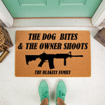 Personalized funny doormat with rifle graphic and text reading the dog bites and the owner shoots, this custom coir welcome mat for front porch decor features a durable natural fiber construction for a humorous home entrance