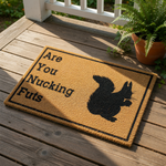 Funny squirrel doormat with a natural coir texture and black border, featuring a silhouette of a squirrel and the humorous text Are You Nucking Futs, making this a perfect cheeky welcome mat for your front porch or entryway decor.