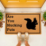 Funny squirrel doormat with a humorous pun phrase printed on natural coir fiber, featuring a black silhouette of a squirrel holding a nut, perfect for a front porch welcome mat or a quirky housewarming entrance decor for animal