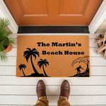 Personalized beach house doormat with palm tree and surfer design on natural coir fiber, featuring custom family name text for a coastal home entrance, outdoor welcome mat for front porch decor, and tropical summer house decor.