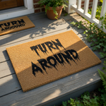 Turn Around doormat with spooky dripping black text on a natural coir fiber welcome mat, perfect for a scary front porch decor, funny Halloween entryway rug, or a gothic home entrance floor mat for visitors to see at your front